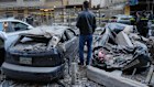 A man stands next to destroyed cars at the site where Israeli airstrikes hit apartments in Beirut, Lebanon, Wednesday, March 11, 2026. (AP Photo/Hussein Malla)