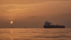 The sun rises behind tankers anchored in the Strait of Hormuz.