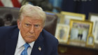 President Donald Trump speaks to reporters as he signs executive orders in the Oval Office of the White House.