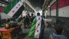 Opposition supporters carry opposition flags along the Al-Hamidiyeh market inside the old walled city in the Syrian capital, Damascus