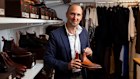 RM Williams CEO Paul Grosmann holding a signature handcrafted leather boot, symbolizing the brand’s $324 million revenue growth and Australian heritage.