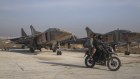 Syrian opposition fighters ride on a motorcycle past Syrian army planes at the Al-Nayrab military airport after they took control of the facility in the outskirts of Aleppo, Syria, on Monday. 