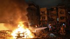 Firefighters work to extinguish a blaze after a missile launched from Iran struck Tel Aviv on Monday.