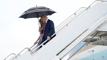 US President Donald Trump and first lady Melania Trump walk down the stairs after exiting Air Force One in NASA Shuttle Landing Facility in Florida. 