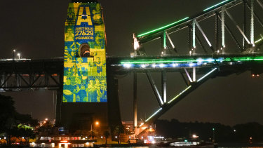 Sydney ferries sail past the illuminated pylon of the Sydney Harbour Bridge on Thursday night. 