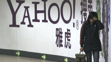  A woman walks past a Yahoo billboard in a Beijing subway.