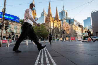 Commuters are wearing face masks in the CBD as they make their way to work this morning. 