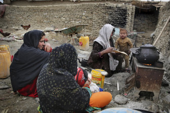 An Afghan family cooks food out in the open at a camp for internally displaced people in Kabul.