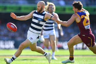 Geelong's Gary Ablett gets his kick away despite the efforts of Alex Witherden (right). 