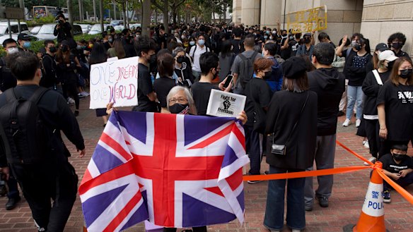 A woman holds a British flag as supporters queue up outside a court to try to get in for a hearing in Hong Kong on Monday.