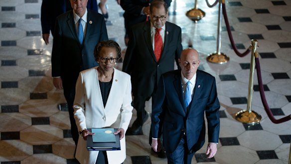 Clerk of the House Cheryl Johnson, left, and House Sergeant at Arms Paul Irving pass through Statuary Hall at the Capitol to deliver the articles of impeachment against President Donald Trump to the Senate.