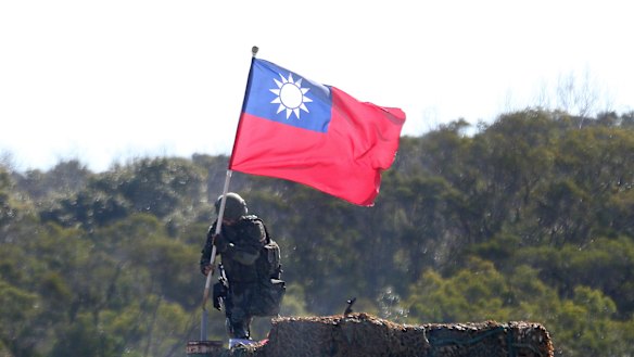 A soldier holds a Taiwanese flag during a military exercise aimed at repelling an attack from China in Hsinchu County, northern Taiwan. 