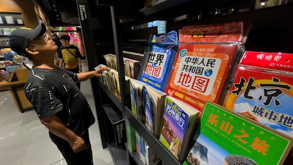 People browse near the new map, on display for sale at a bookshop in Beijing.