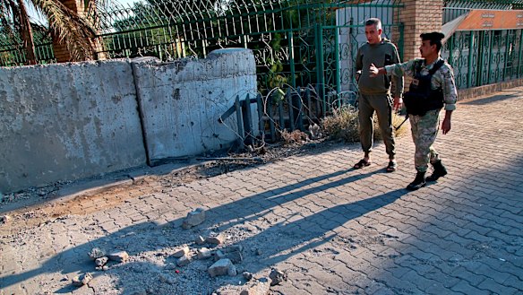 Security forces inspect the scene of the rocket attack at the gate of al-Zawra public park in Baghdad, Iraq in November.