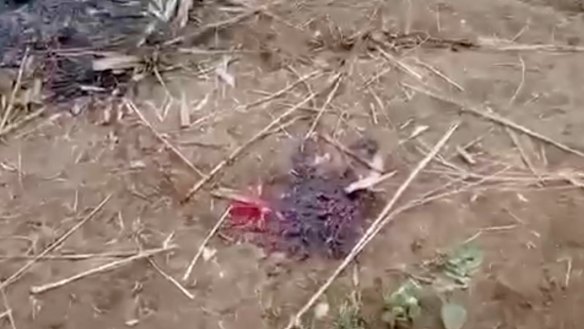 A bloodstain is seen on the ground near charred corpses in Don Taw village in Sagaing, Myanmar, in December 2021. 