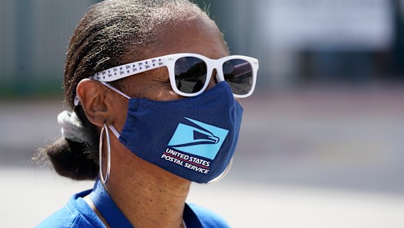 Wearing a mask to prevent the spread of coronavirus, Miami postal worker Samantha Wims demonstrates during the 'National Day of Action to Save the People's Post Office'.