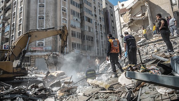 Palestinians search for survivors in a destroyed building after an Israeli air strike in Gaza City on Sunday.
