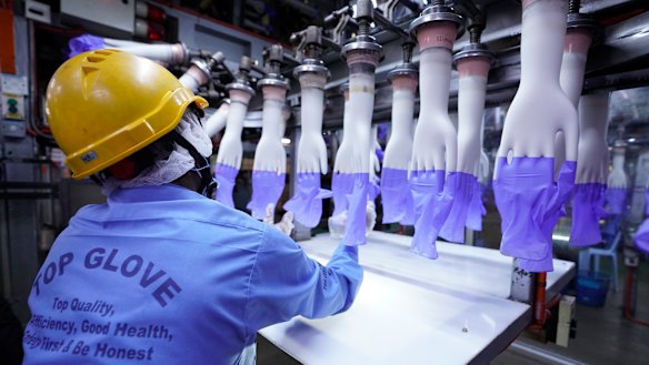 A worker inspects disposable gloves at the Top Glove factory in Shah Alam on the outskirts of Kuala Lumpur, Malaysia. 