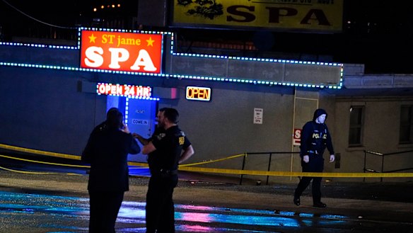 Law enforcement officials confer outside a massage parlour following a shooting in Atlanta.