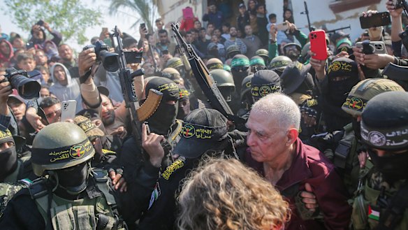 Gadi Moses, 80, centre right,  is escorted by Hamas and Islamic Jihad fighters.