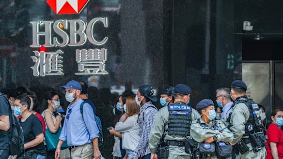 Riot police stand guard in front of an HSBC branch in Hong Kong's Central district on Friday. 