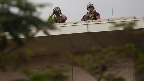 US soldiers stand guard on the rooftop of the US Embassy.