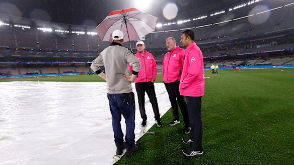 MCG curator Matt Page confers with umpires at the MCG during the washed out game between Australia and England.