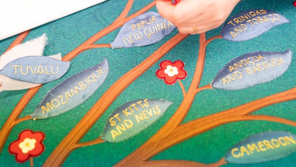 Embroiders work on part of the anointing screen during a visit by Charles and Camilla to the Royal College of Needlework at Hampton Court Palace, Surrey.