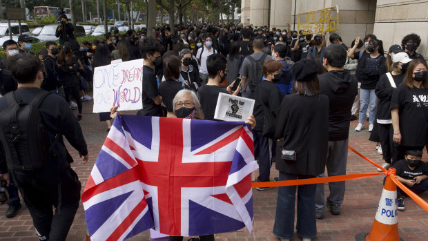 A woman holds a British flag as supporters queue up outside a court to try to get in for a hearing in Hong Kong on Monday.