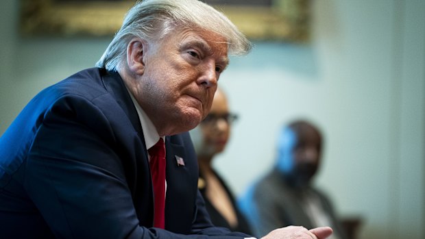 US President Donald Trump listens during a meeting with recovered COVID-19 patients in the Cabinet Room of the White House in Washington, DC. 