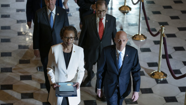 Clerk of the House Cheryl Johnson, left, and House Sergeant at Arms Paul Irving pass through Statuary Hall at the Capitol to deliver the articles of impeachment against President Donald Trump to the Senate.