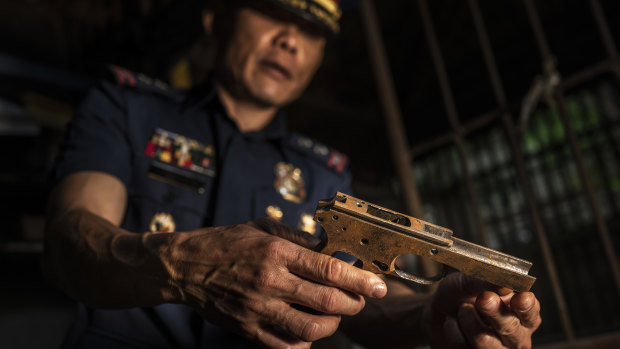 Col. Jaime Quiocho holds a confiscated gun part made by illegal gunsmiths in Danao.