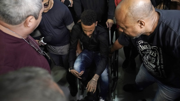 Brazilian soccer player Neymar arrives to a police station, in a wheelchair due to an ankle injury, in Rio de Janeiro, on THursday. Polcie say he will testify soon.