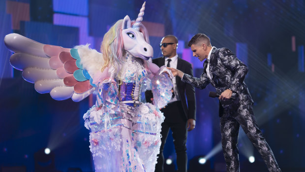 The Masked Singer contestant Unicorn with the show's host Osher Günsberg. 