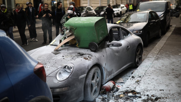 A trashed Porsche car is pictured during scuffles with riot police during the 13th weekend of protests throughout France on Saturday.