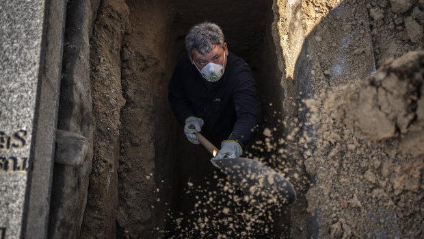 An undertaker prepares a grave for the burial of a victim of the COVID-19 at the Almudena cemetery in Madrid on Saturday. 
