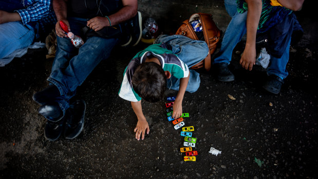 A child plays with toys as a group of Central American asylum seekers rest at a migration checkpoint in Mexico. An 8-year-old boy who was part of a migrant caravan died in US custody.