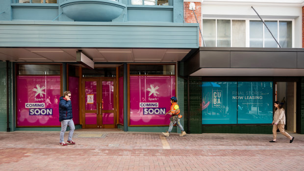 Pedestrians walk past empty shops in Wellington in late August.