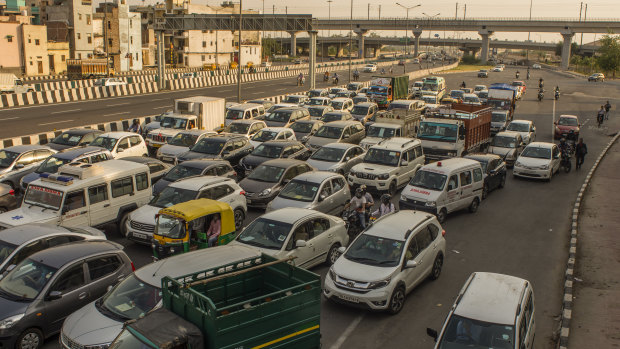 Vehicles driving on a road, after the country relaxed its lockdown restriction in Delhi, India. 