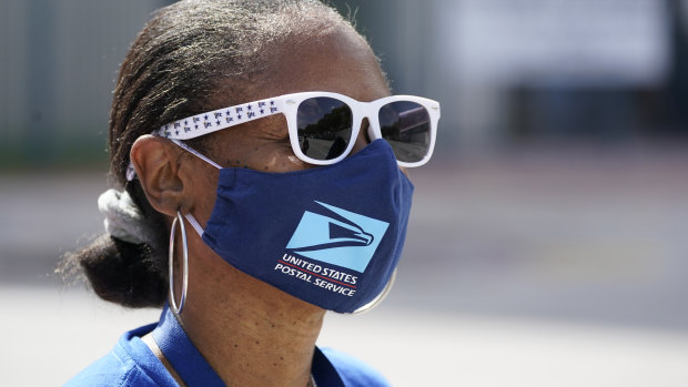 Wearing a mask to prevent the spread of coronavirus, Miami postal worker Samantha Wims demonstrates during the 'National Day of Action to Save the People's Post Office'.