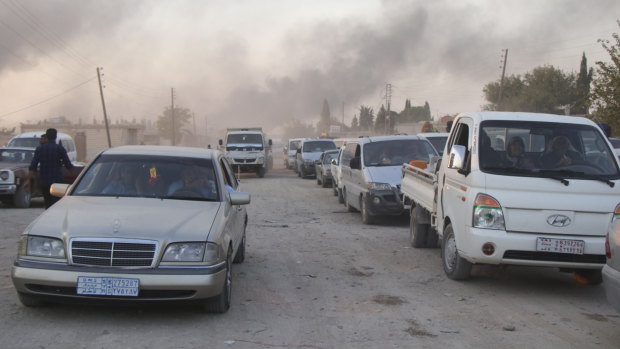 Syrians flee shelling by Turkish forces in Ras al Ayn, north-east Syria.