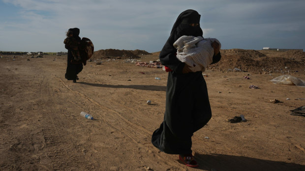 Women who were evacuated out of the last territory held by Islamic State militants carry their children outside Baghouz, Syria, on Tuesday, local time.