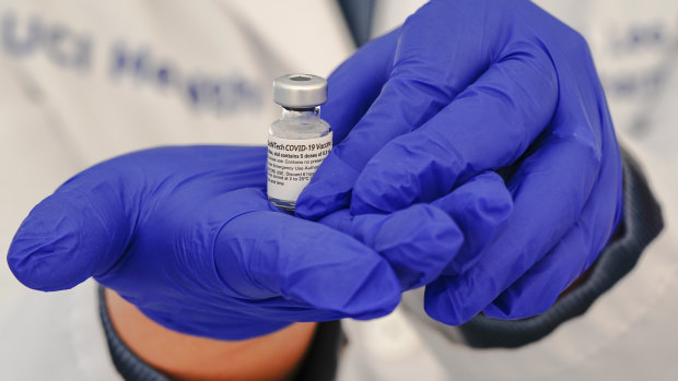 A pharmacist holds a vial of the Pfizer-BioNTech Covid-19 vaccine.