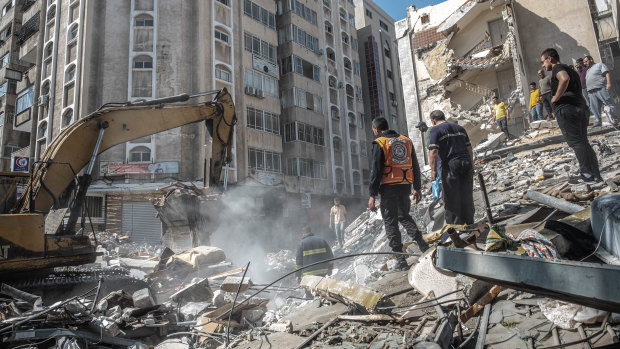 Palestinians search for survivors in a destroyed building after an Israeli air strike in Gaza City on Sunday.