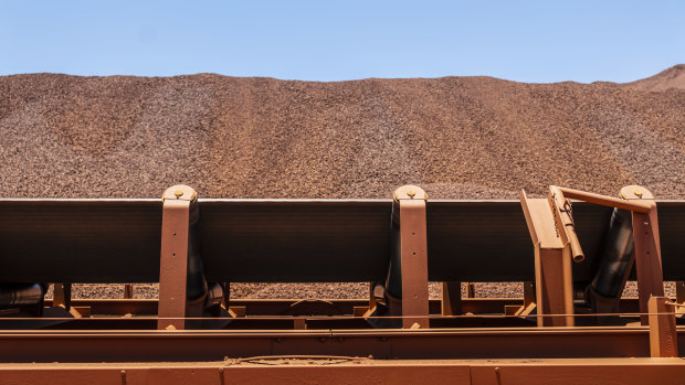 An ore conveyor belt in front of an iron ore stockpile at BHP's Jimblebar facility in the Pilbara.