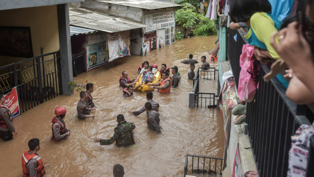 A rescue team evacuates residents from their flooded houses in Jakarta.