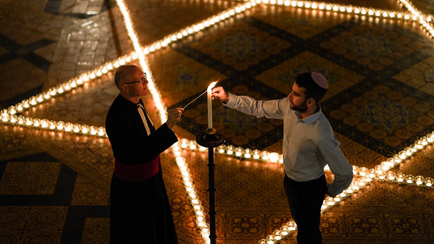 Reverend Canon Christopher Collingwood and Joshua Daniels light some of the 600 candles shaped as a Star of David on the floor of York Minster as part of a commemoration for Holocaust Memorial Day.