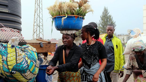 People wash their hands at the Poids Lourd checkpoint on the Congolese side of the border with Rwanda.