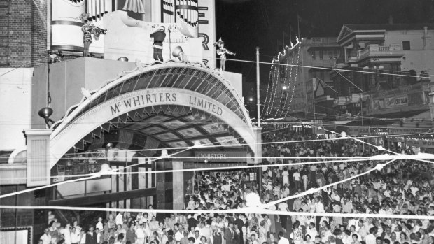 Crowds outside McWhirters in Fortitude Valley with the Christmas display above the entrance, date unknown.