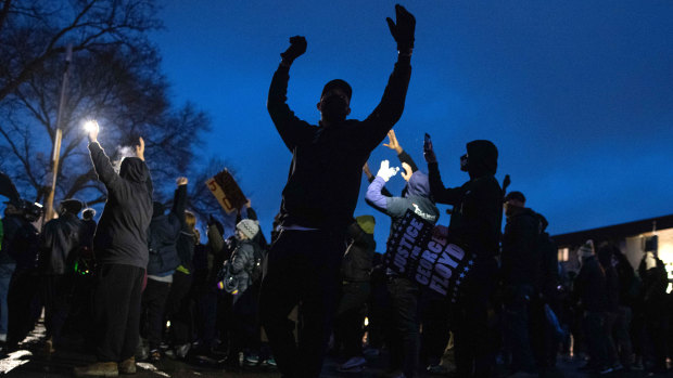 Demonstrators raise their hands during protests in Brooklyn Centre, Minnesota.